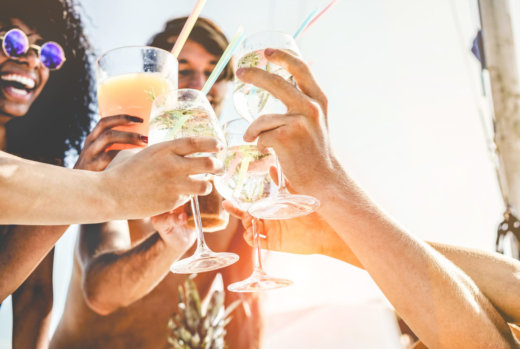 photo showing a group of friends raising glasses of clear fizzy beverages