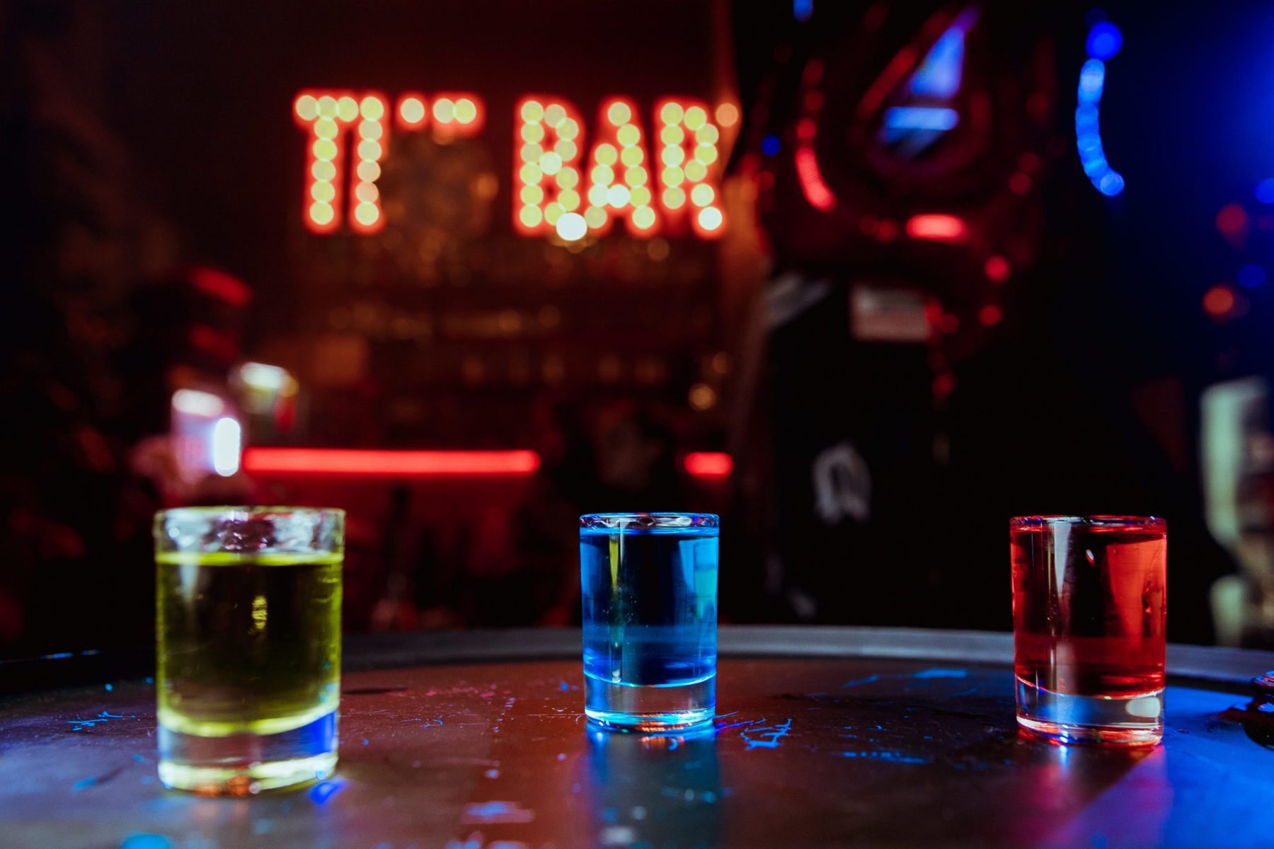 photo of glowing shots in different colours at a bar