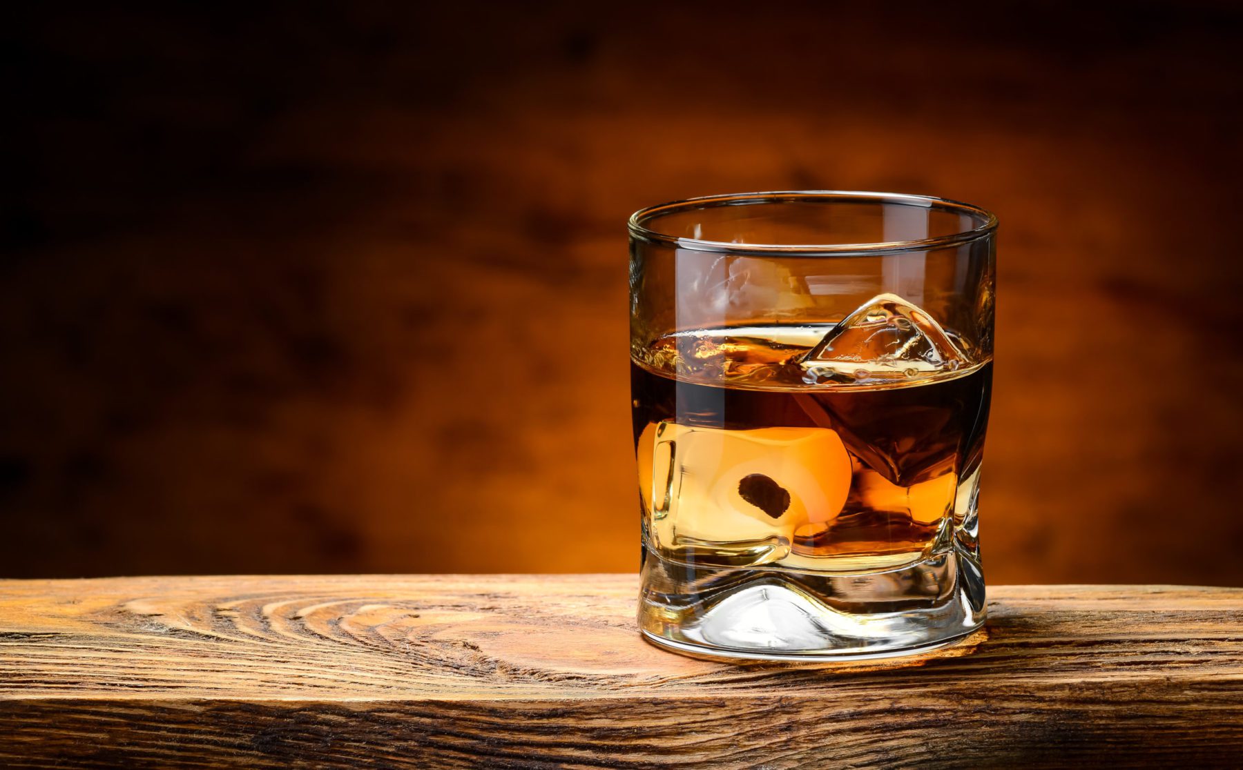 photo of a tumbler of whiskey on the rocks