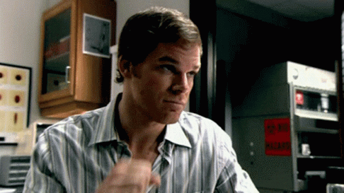 gif of TV serial killer Dexter Morgan giving a single air fist bump in someone's direction while looking unimpressed 